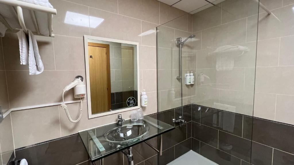 Eenpersoonskamer | Badkamer | Een haardroger, handdoeken, zeep, shampoo