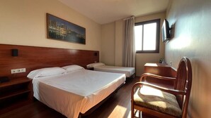A hotel room with two beds, a wooden headboard, a television mounted on the wall, a window with curtains, and a chair. - B&b Hotel Tarragona Reus  (Reus)