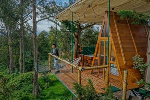 A wooden cabin with a rope bridge, surrounded by trees. - Samay Collections (Tababela)