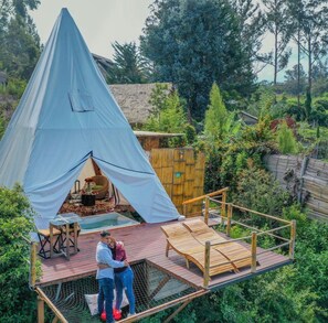 A dome-shaped tent with a wooden deck and lounge chairs. - Samay Collections (Tababela)