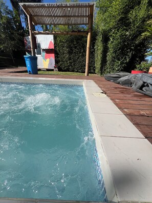 A swimming pool with a wooden deck and a pergola. - Samay Collections (Tababela)