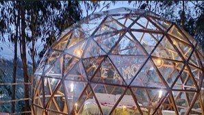 A geodesic dome structure with a bed inside, surrounded by a wooden deck and a pool. - Samay Collections (Tababela)
