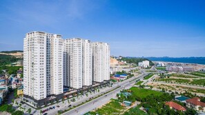 A high-rise residential building with multiple floors, surrounded by roads and greenery. - New Life Tower Bai Chay (Bai Chay)