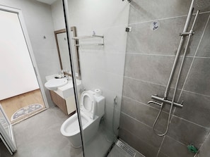 A modern bathroom with a toilet, sink, and shower. - New Life Tower Bai Chay (Bai Chay)