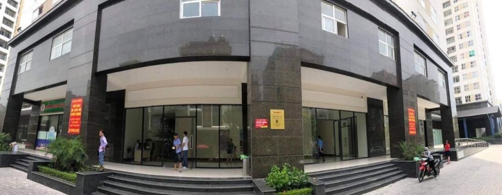 A modern building with a curved facade, large glass entrance, and a signboard.