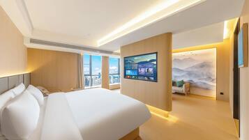 A modern hotel room with a large bed, a mounted TV, and a city view.
