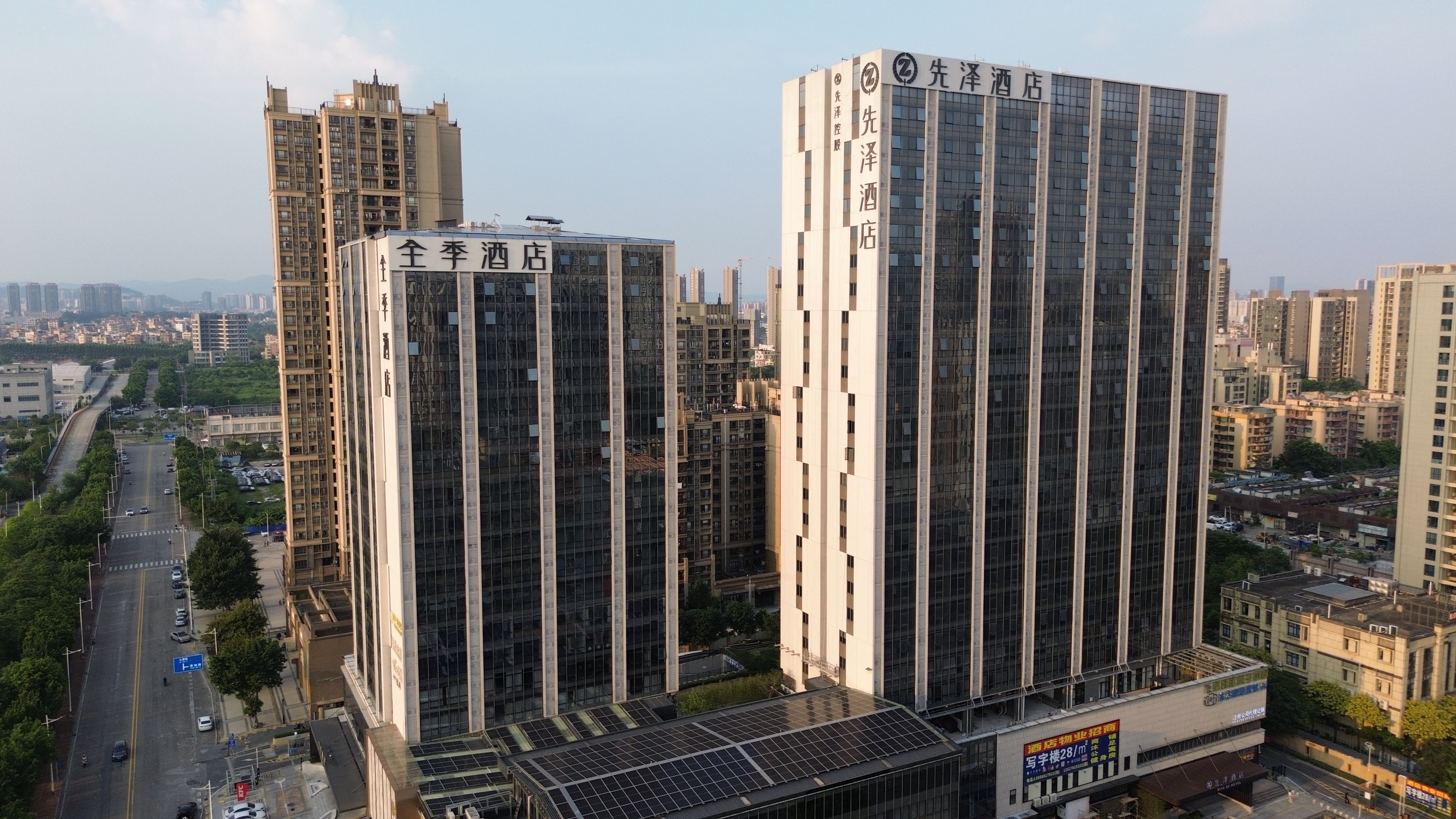 Un hotel moderno de gran altura con fachada de vidrio, varios pisos y señalización llamativa.