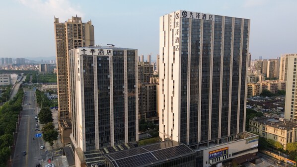 Un hotel moderno de gran altura con fachada de vidrio, varios pisos y señalización llamativa.