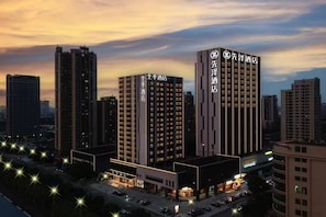 A hotel with multiple high-rise buildings, featuring illuminated signage and a modern architectural design. - Xianze Hotel (Guangzhou)