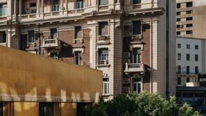 A multi-story building with balconies, windows, and a partial view of a lower structure. - Brassbell Dt Hannaux Tahrir Sq (Cairo)
