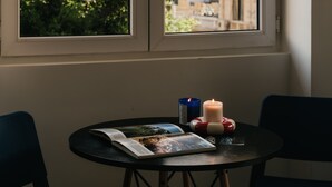 A table with a book, a candle, and a blue container. - Brassbell Dt Hannaux Tahrir Sq (Cairo)