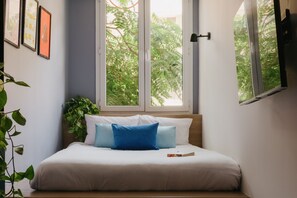 A bedroom with a bed, a window, and a plant. - Brassbell Dt Hannaux Tahrir Sq (Cairo)