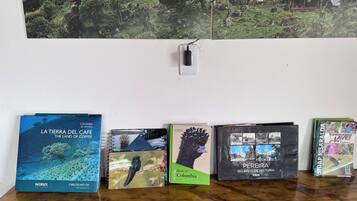 A collection of books on a wooden surface with a wall in the background.