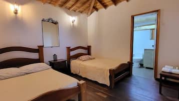 A room with two wooden beds, a wooden ceiling, and a mirror on the wall.