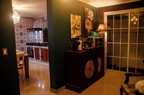 A kitchen with patterned tiles, a dining area with a chair, and a sliding glass door leading to a balcony. - Orho Hotel Boutique 15 Minutes From PTY Airport (Tocumen)