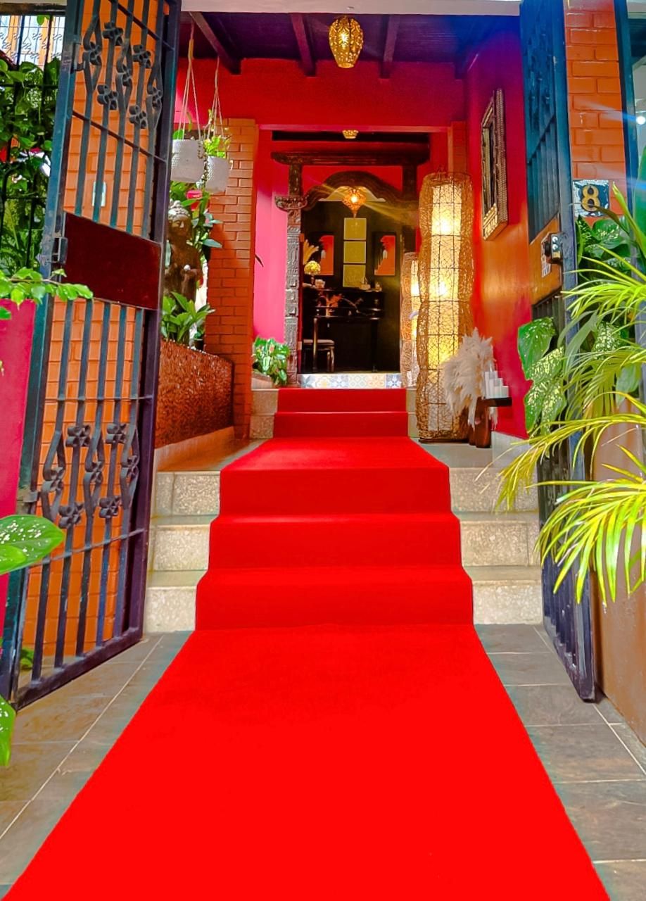 A red carpeted staircase leading to a room with a view of the outside.