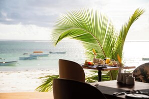 Una tavola apparecchiata per la colazione con vista sul mare e sulle barche.