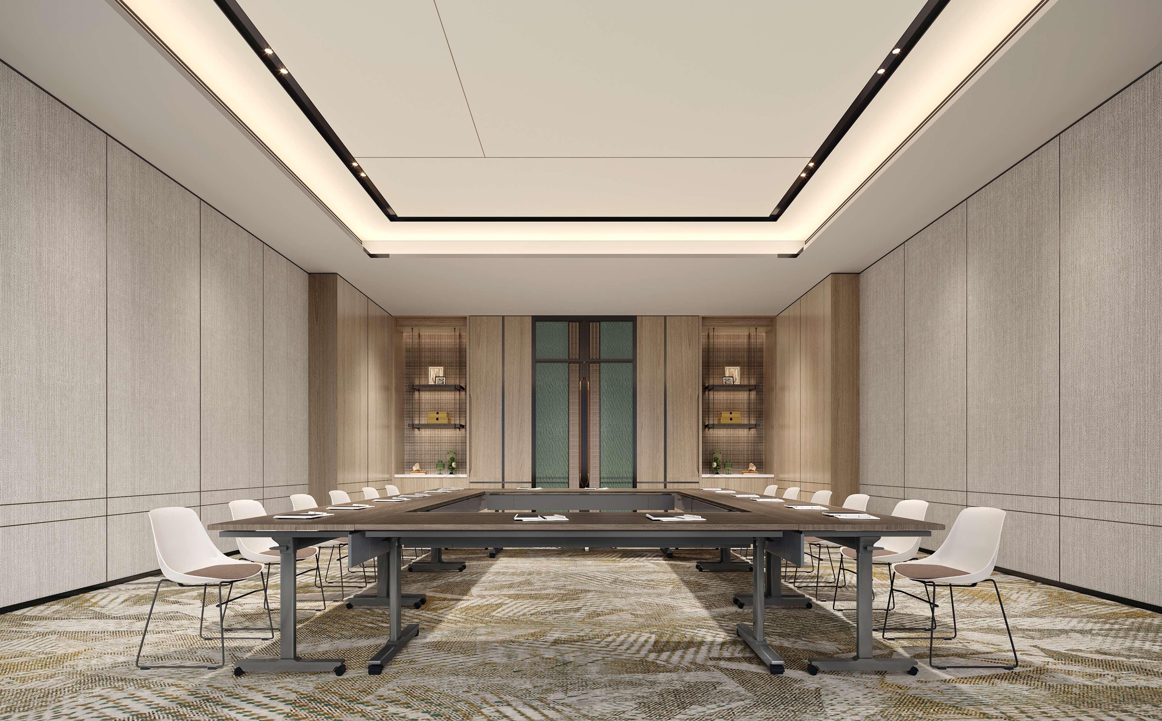 Une salle de conférence avec une longue table, des chaises blanches, une moquette à motifs et un design de plafond moderne.
