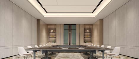 A conference room with a long table, white chairs, a patterned carpet, and a modern ceiling design.