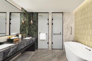 Une salle de bain moderne avec deux lavabos, une grande baignoire et une douche à l’italienne.