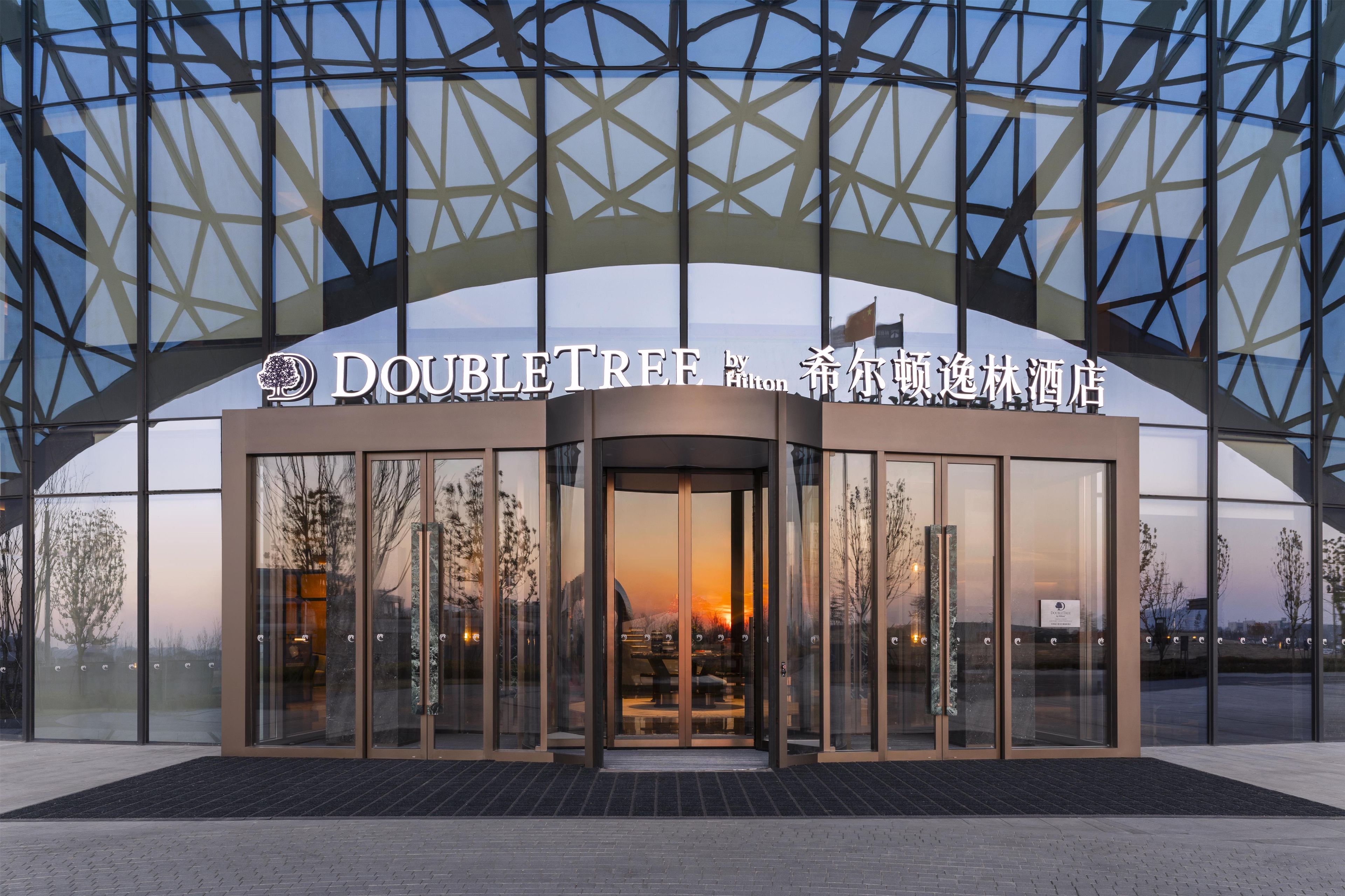 L’entrée d’un hôtel, dotée d’une façade en verre et d’une architecture moderne.