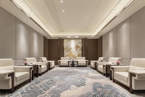 A spacious conference room with a large, patterned carpet, multiple seating arrangements, and a large artwork on the wall. - Doubletree by Hilton Zhengzhou Airport Aerotropol (Zhengzhou)