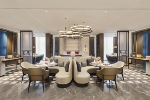 A modern hotel lobby with a central seating area, a staircase, and a view of the city. - Doubletree by Hilton Zhengzhou Airport Aerotropol (Zhengzhou)