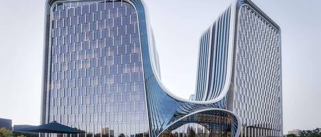 A modern building with a unique curved facade and a glass entrance.