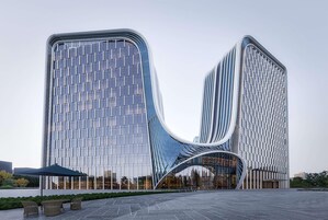 Un edificio moderno con una fachada curva distintiva y una entrada de vidrio.