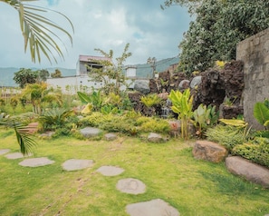 A garden with a variety of plants and a small waterfall feature. - Tribhuwana Padma Resort (Kintamani)