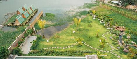 Ein Resort mit Schwimmbad, einem Garten mit einem Gehweg und schwimmenden Strukturen auf dem Wasser.