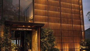 Un bâtiment moderne doté d’une façade en bois, sur lequel on peut lire en grand le nom « Tribhuvana Padma ».