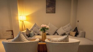 A modern living room with a sofa, two armchairs, a coffee table, a lamp, and a vase with flowers. - Tribhuwana Padma Resort (Kintamani)