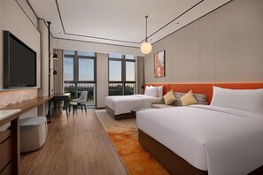 A modern hotel room with a large bed, a desk, a chair, and a TV. - Hilton Garden Inn Guiyang Gui'an New Area (Guiyang)