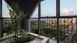 Un balcón con vista a un paisaje urbano, incluyendo edificios y calles.