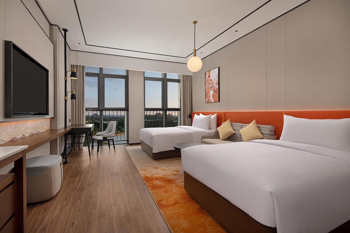 Camera d'albergo moderna con un letto grande, una scrivania, una sedia e una televisione.