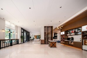 A spacious lobby with a central island, seating area, and a reception desk. - Hilton Garden Inn Yanqi Downtown (Hejing)