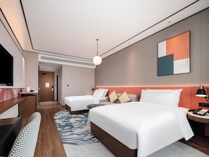 A modern hotel room with a large bed, a smaller bed, a desk with a TV, and a bathroom visible through an open door. - Hilton Garden Inn Yanqi Downtown (Hejing)