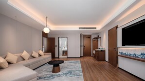 Una sala de estar moderna con un sofá, una mesa de centro, un televisor y piso de madera.
