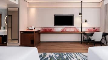 Een moderne hotelkamer met een flatscreen-tv, een bureau, een stoel en een bed.