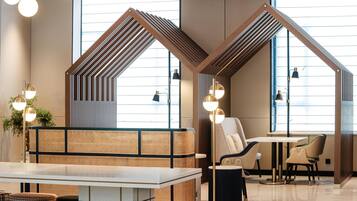 A modern interior with a seating area, a table, and a lamp.