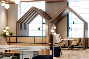 Un interior moderno con una zona de estar, una mesa y una lámpara.