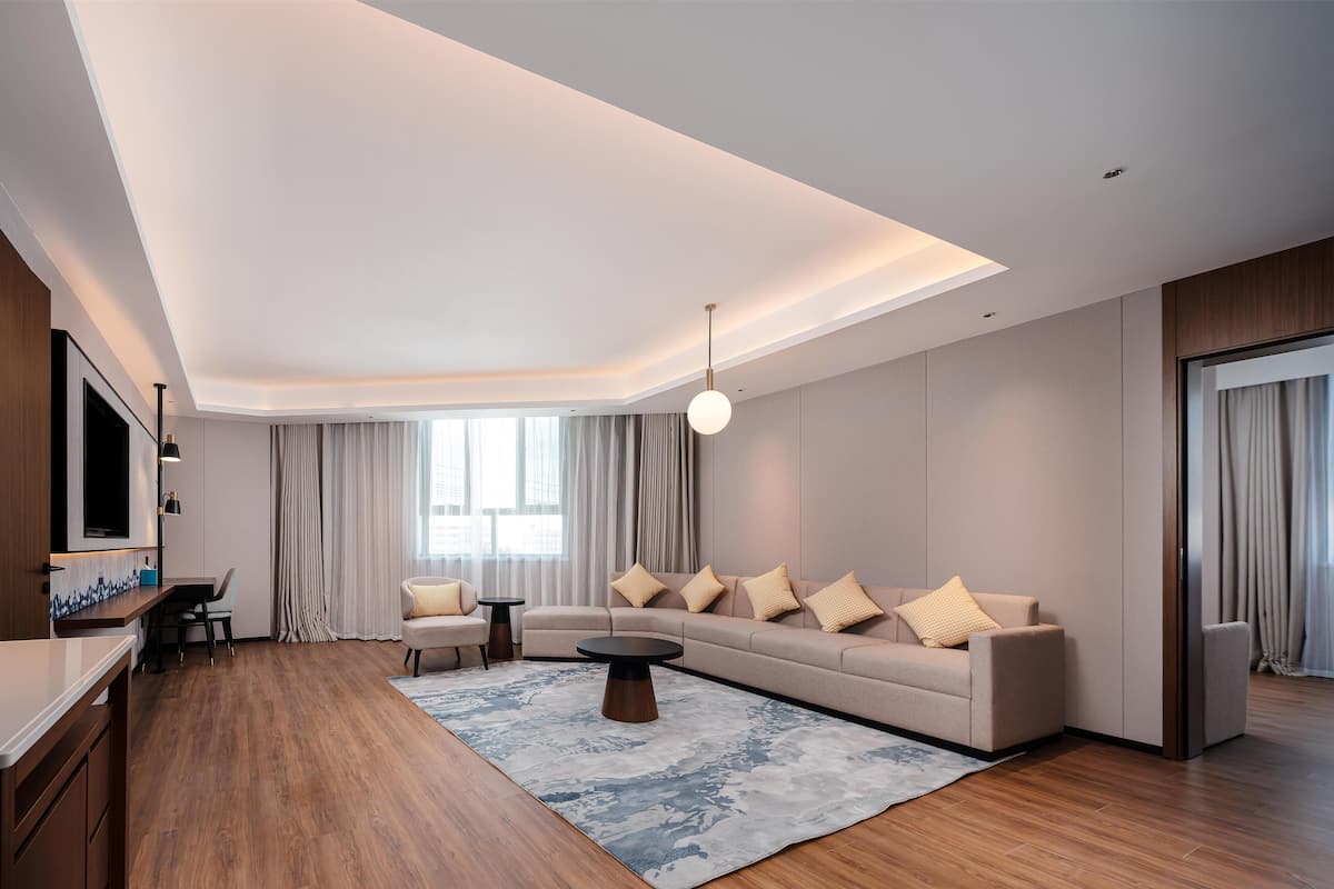 A modern living room with a sofa, coffee table, and a TV mounted on the wall.