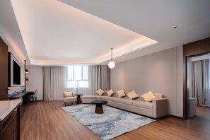 A modern living room with a sofa, coffee table, and a TV mounted on the wall.