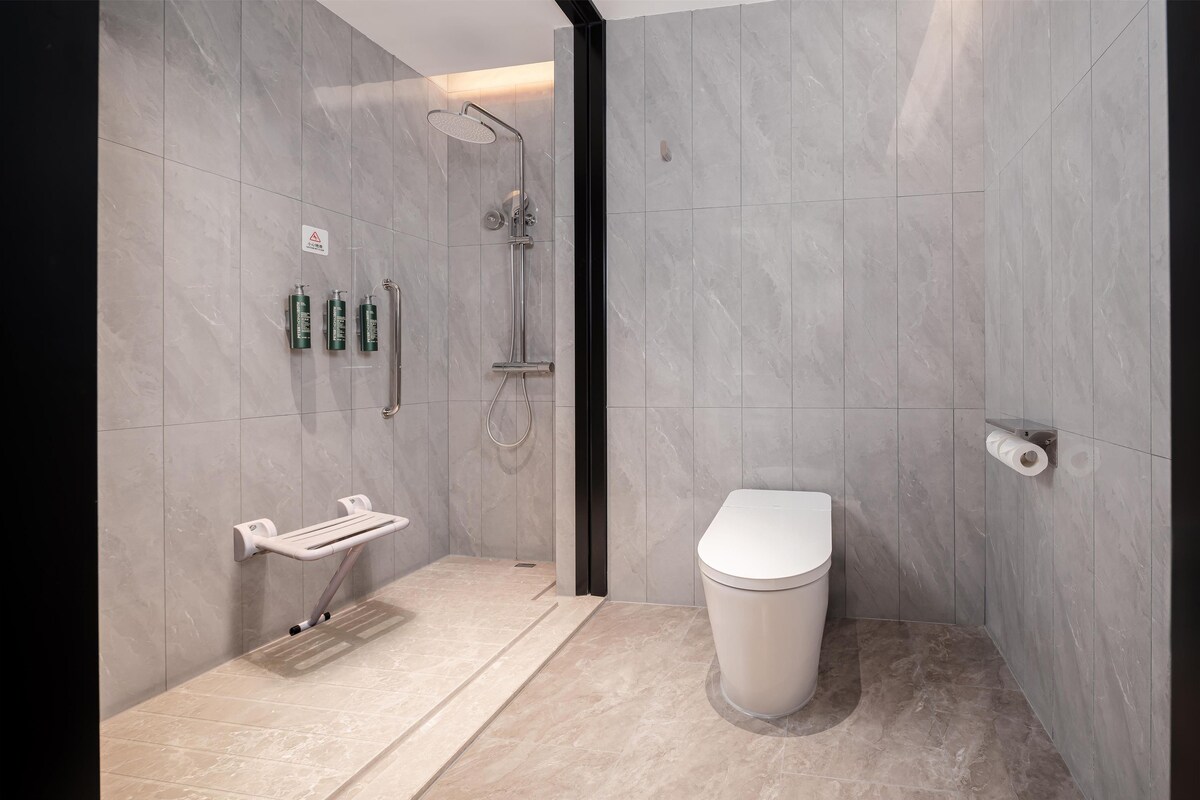 Un baño moderno con ducha, inodoro y perchero para toallas.