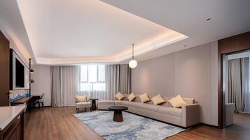 A modern living room with a sofa, coffee table, and a TV mounted on the wall.