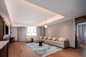 Una sala de estar moderna con un sofá, una mesa de centro y un televisor montado en la pared.