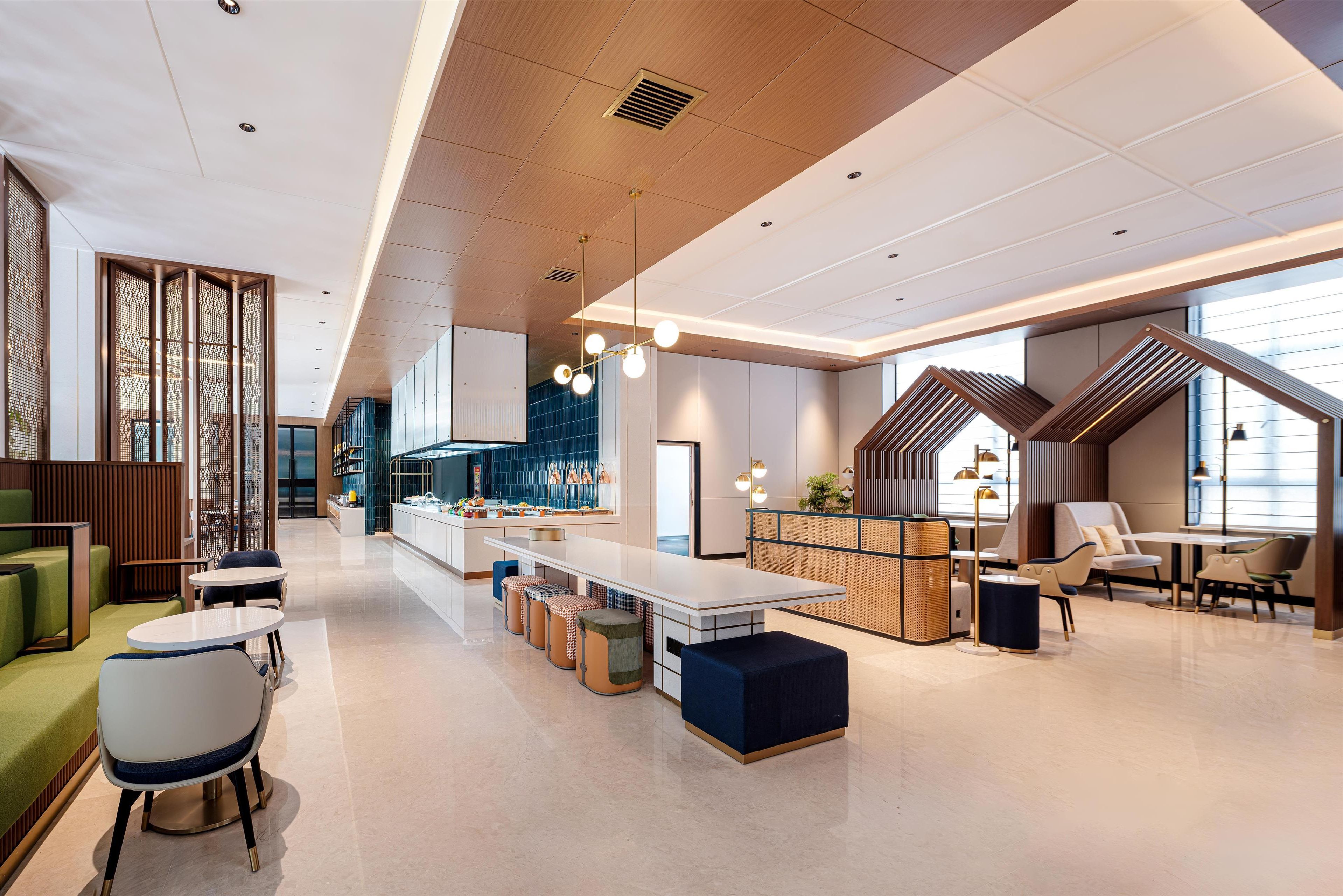 A modern interior with a central dining area, seating arrangements, and a kitchen.