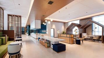 A modern interior with a central dining area, seating arrangements, and a kitchen.