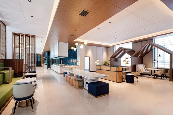 Un interior moderno con zona de comedor central, asientos y cocina.